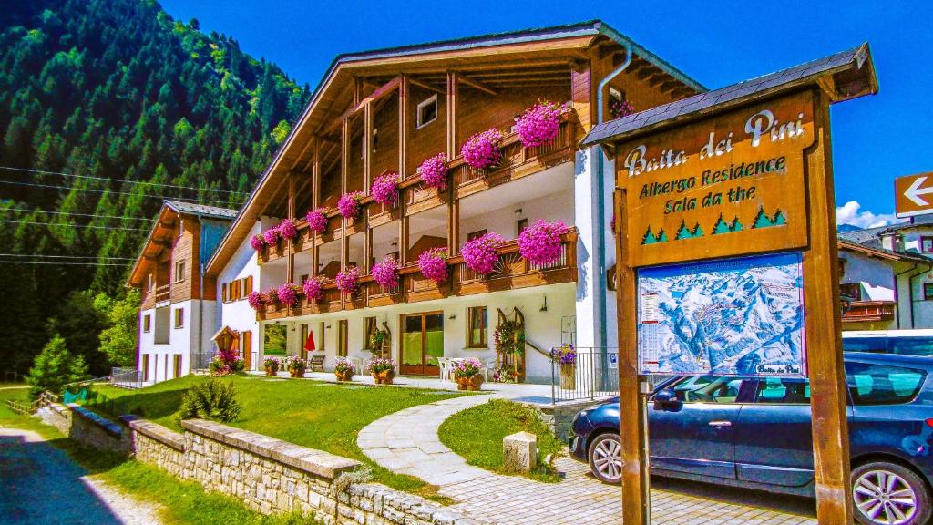 a building with a blue car parked in front of it at Baita dei Pini in Campodolcino