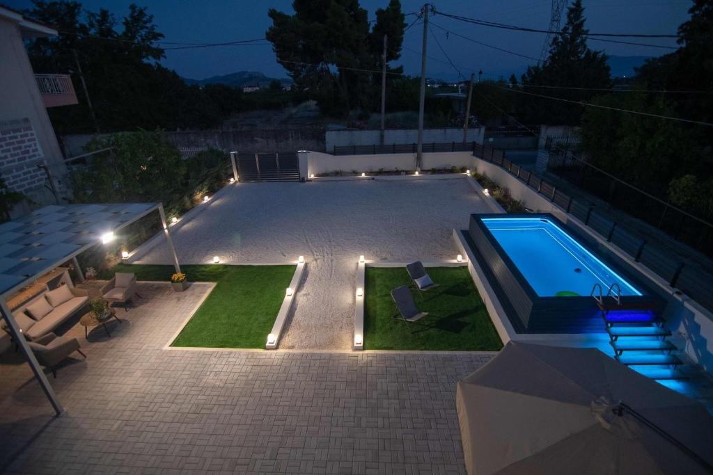 a backyard with a swimming pool at night with lights at Alivio Country House in Nafplio