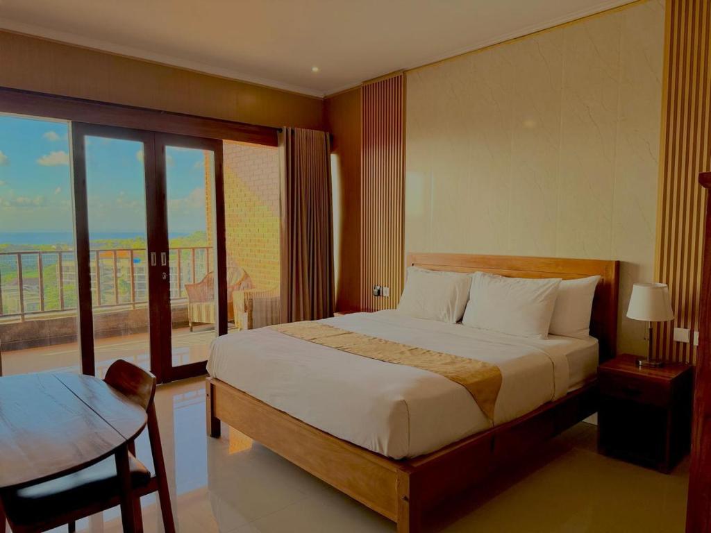a bedroom with a large bed and a balcony at Dreamland View in Uluwatu