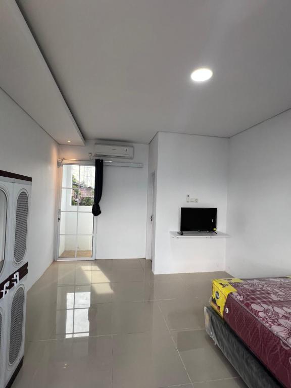 a bedroom with a bed and a tv on a wall at hb co living in Tanjungredep