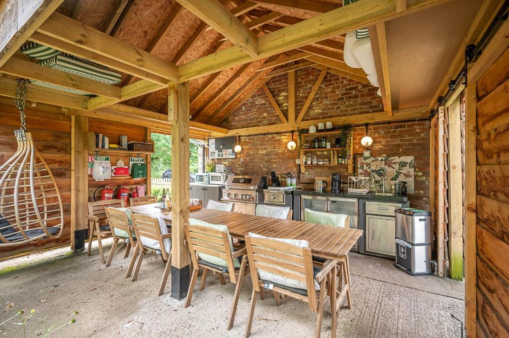 a large kitchen with a wooden table and chairs at Toad Hall Lodges - Luxury Glamping Lodges Near Southwold! in Wangford
