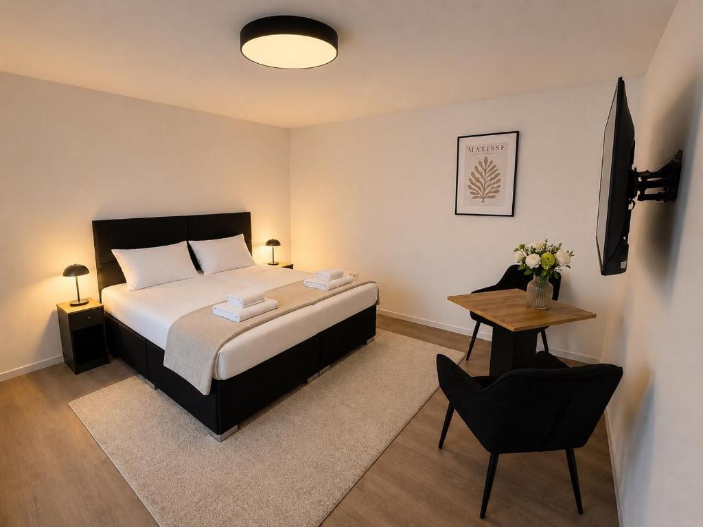 a bedroom with a bed and a table with a chair at Schuster's Apartments in Augsburg