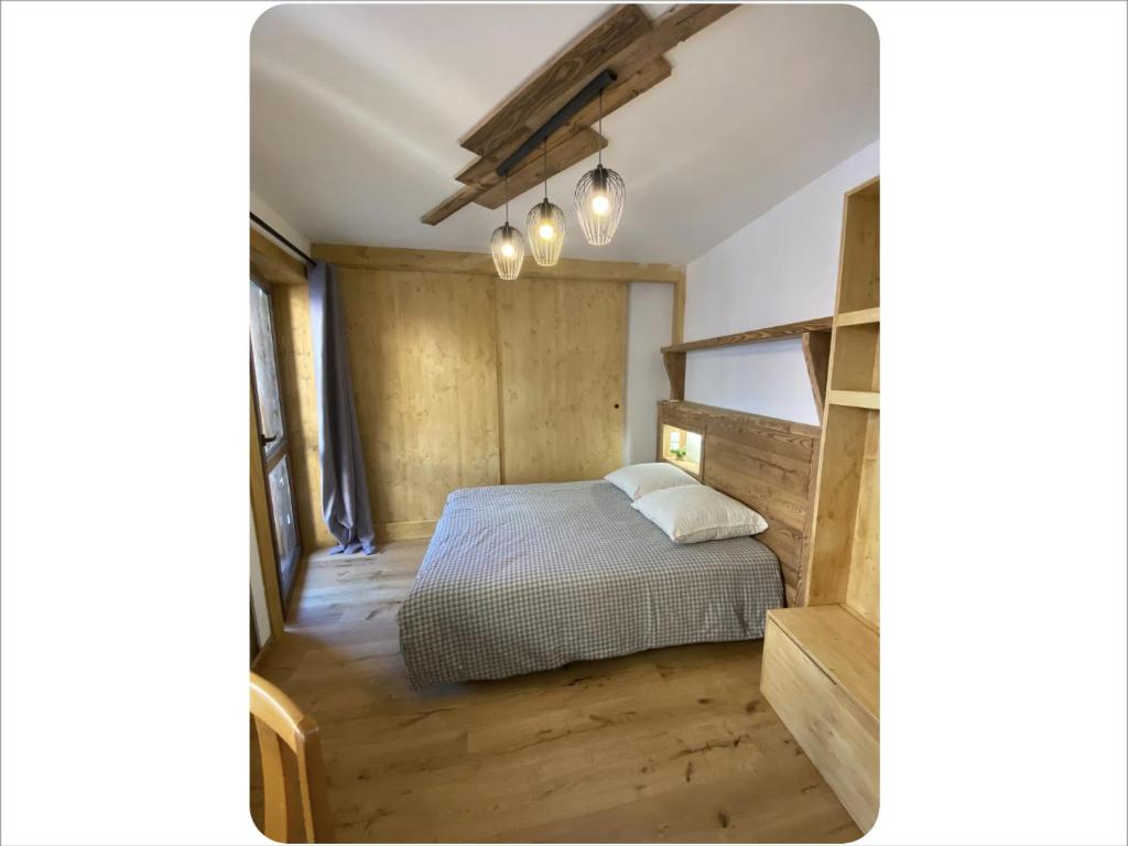 a bedroom with a bed and a wooden floor at Appartement chaleureux cité vauban à Briançon in Briançon