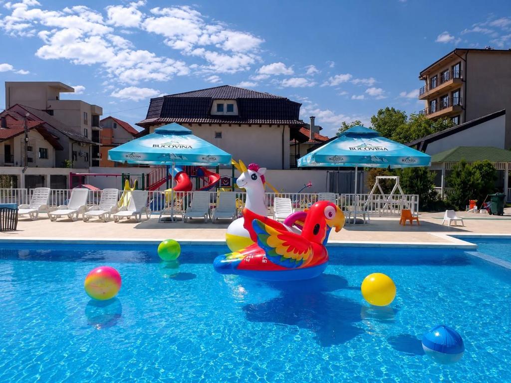 a swimming pool with balls and inflatable ducks and umbrellas at Vila Sangria in Mamaia Sat/Năvodari