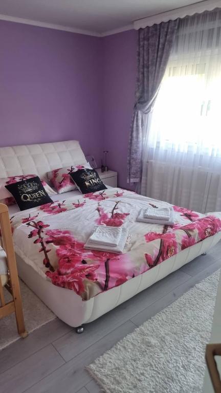 a bedroom with a bed with pink flowers on it at Ramonda Smještaj in Tuzla