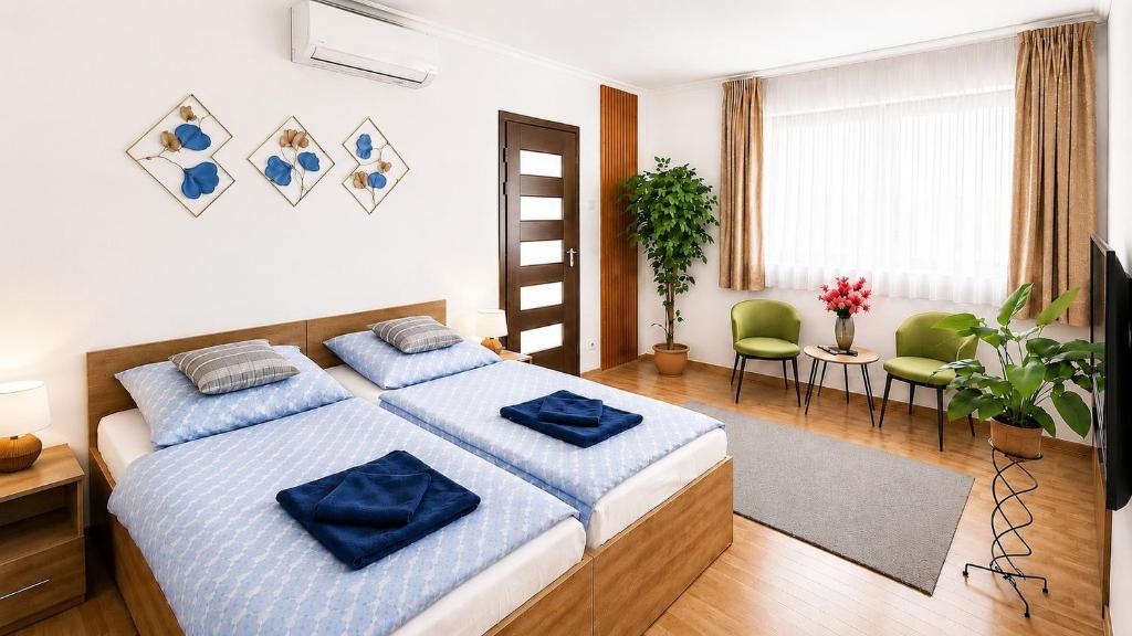 a bedroom with a bed with blue pillows on it at Clementine Apartman by Flats4You in Százhalombatta