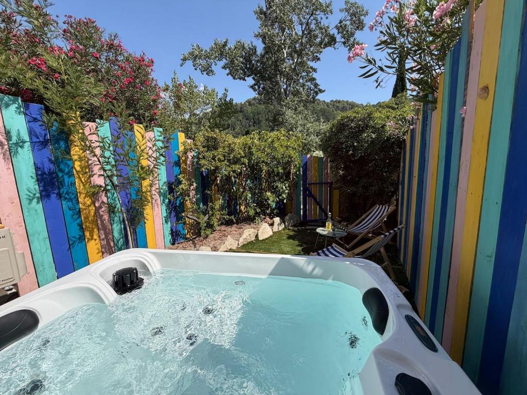 a bath tub in a backyard with a colorful fence at Nyons Riviera in Nyons