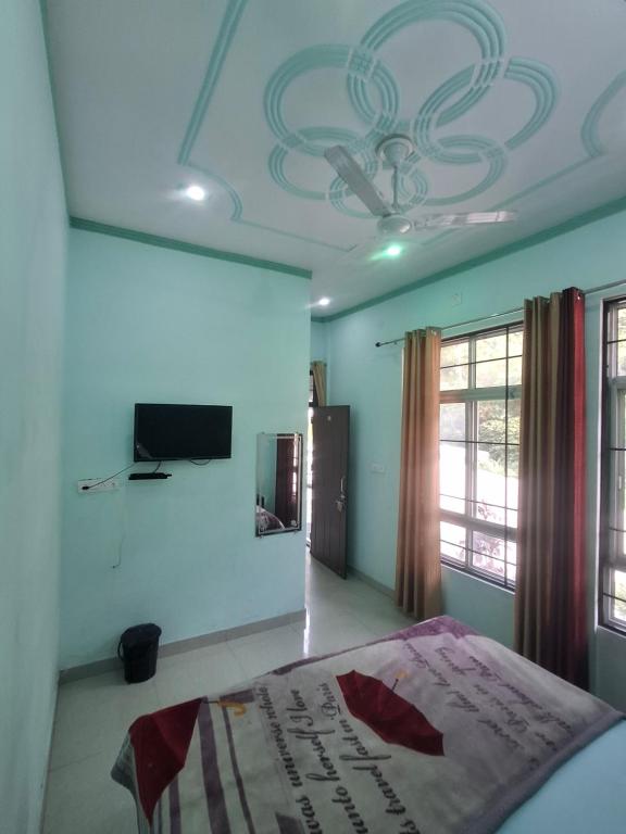 a bedroom with a bed and a tv on the ceiling at K C Hotel & Restaurant in Rudraprayāg