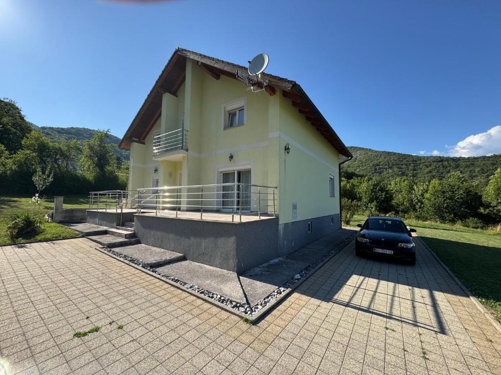 a car parked in front of a house at Kuća za odmor NIMA in Gospić