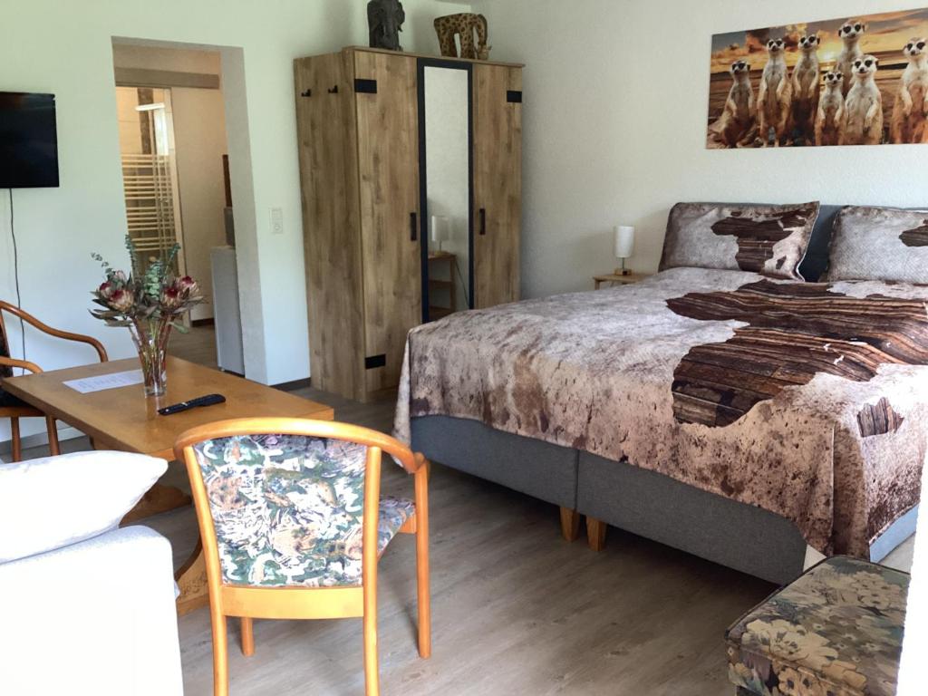 a bedroom with a bed and a table and a chair at Apartment far away from Africa in Steinach