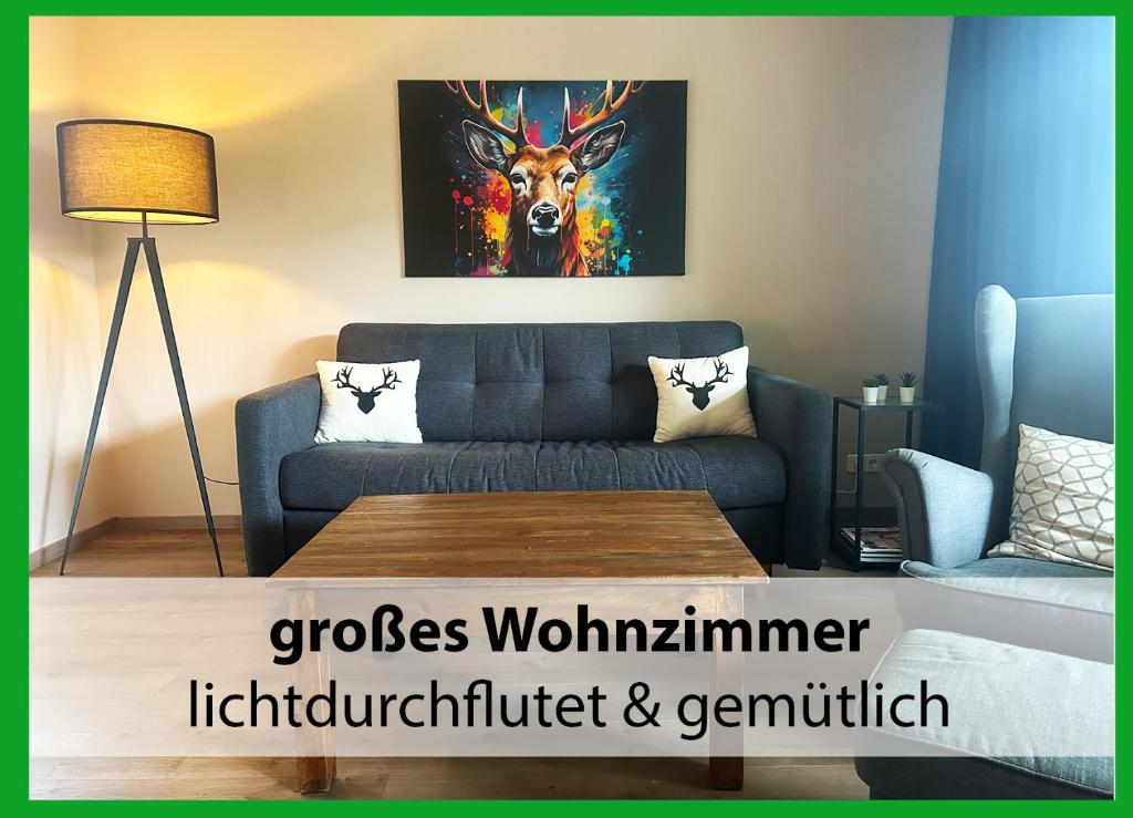 a living room with a couch and a painting of a deer at MARKs Ferienwohnung in Bad Sachsa - waldnah, hundefreundlich, ruhig! Ideal für Paare mit Hund in Bad Sachsa