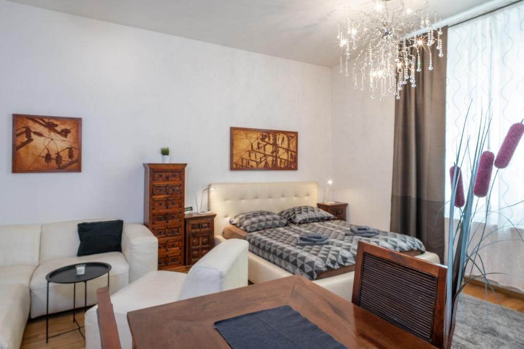 a bedroom with a bed and a living room at Atrium Apartments in Brno