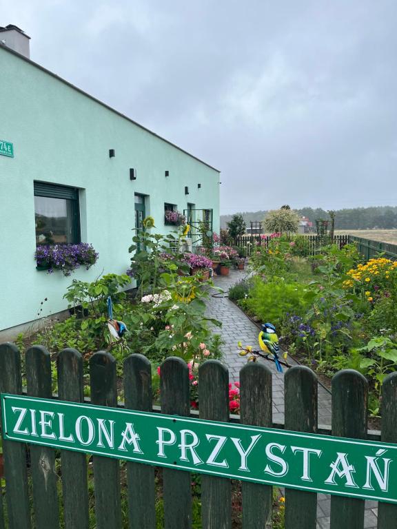 a garden with a sign in front of a building at Zielona Przystań in Boruja