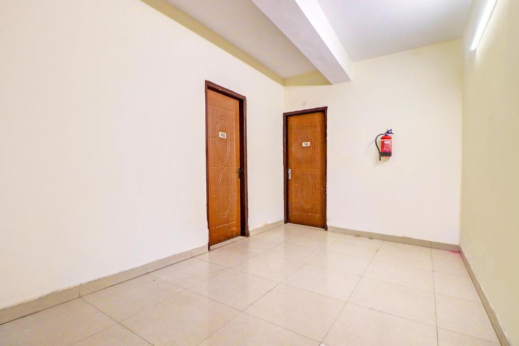 a room with two doors and a tiled floor at Hotel O Honey Inn in New Delhi