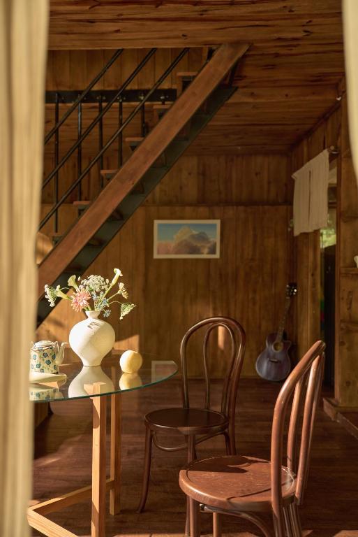 a dining room with a table and chairs and a staircase at Dreaming Retreat Da Lat in Ấp An Kroët