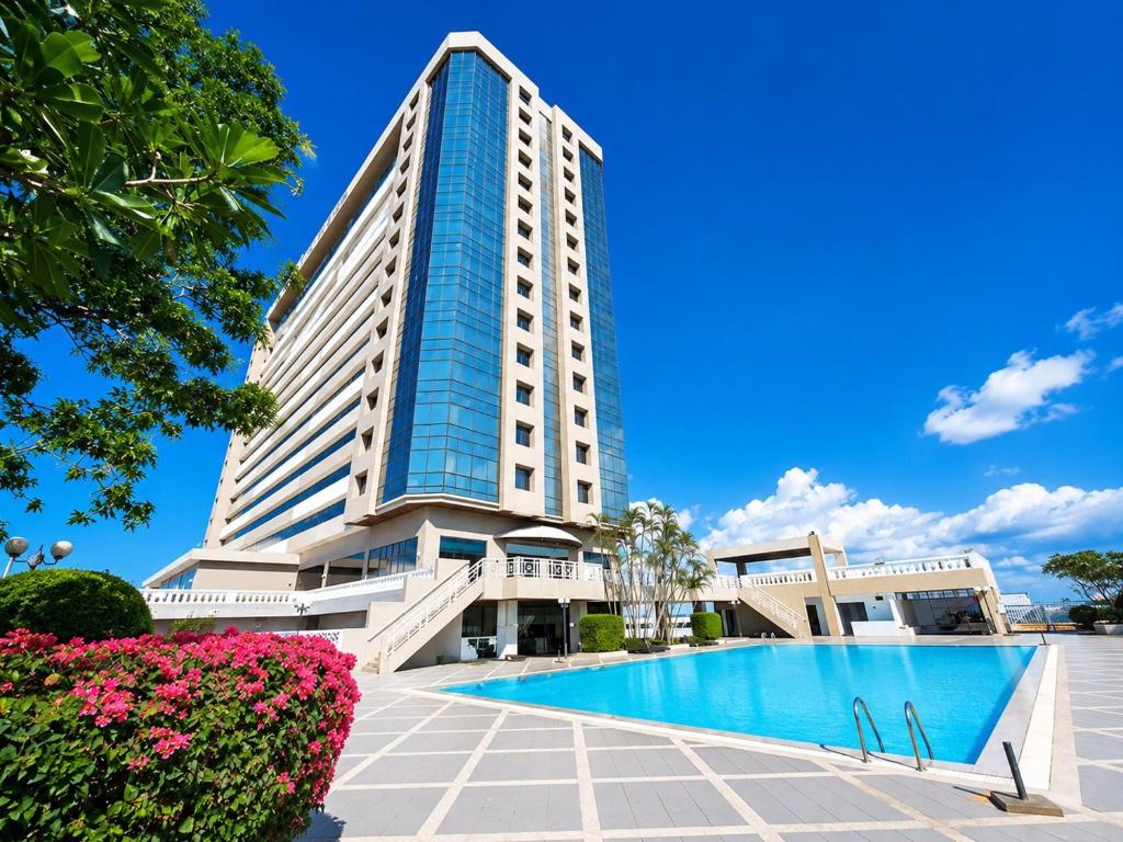 a hotel with a swimming pool in front of a building at The Twin Lotus Hotel in Nakhon Si Thammarat