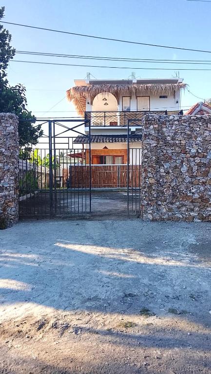 a gate in front of a building with a stone wall at USTIN Villas Lombok in Bumbang