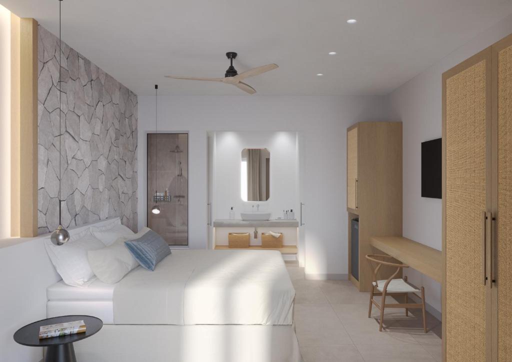 a bedroom with a white bed and a bathroom at Vilos Luxury Suites in Pollonia