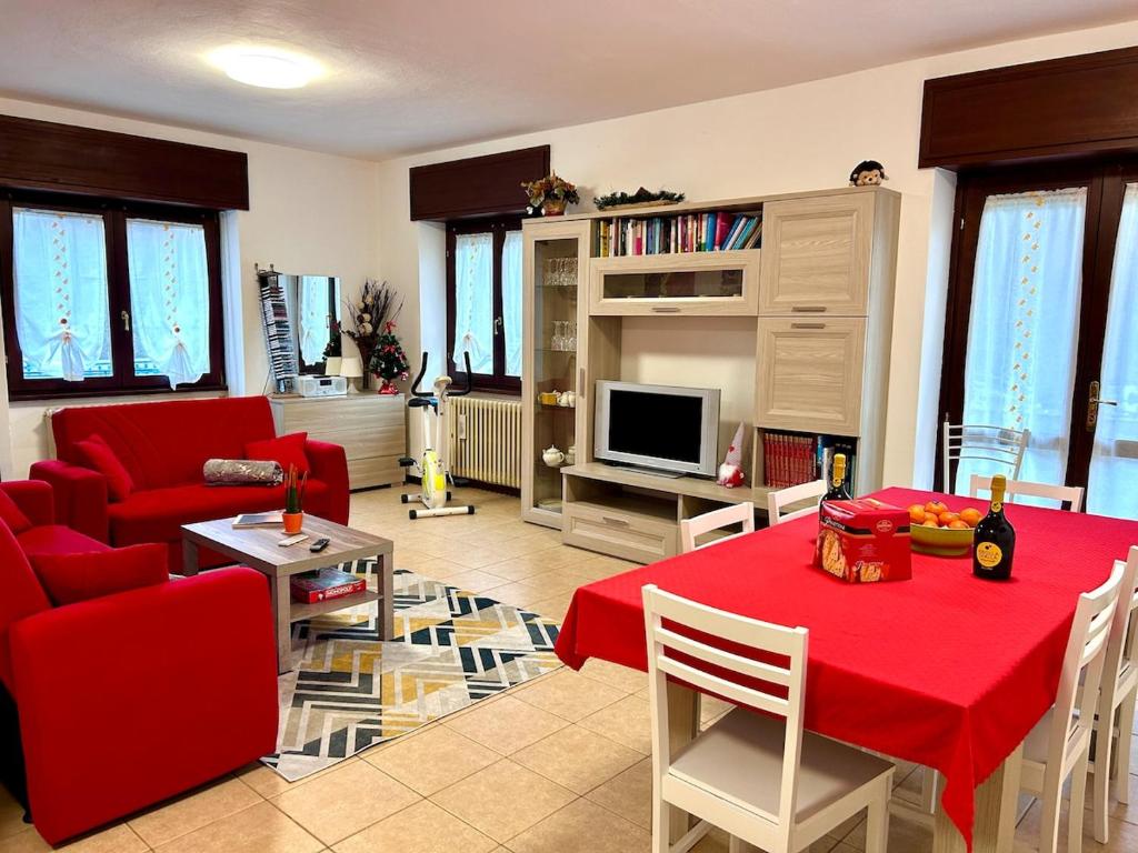 a living room with a red table and a red couch at La Farfalla B&B - Mark&Rosy in Malonno