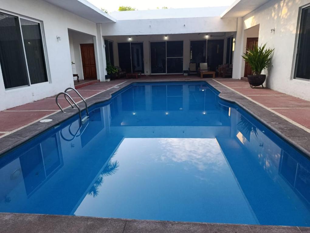 a swimming pool with blue water in a house at Chinelos Ixtapa in Ixtapa