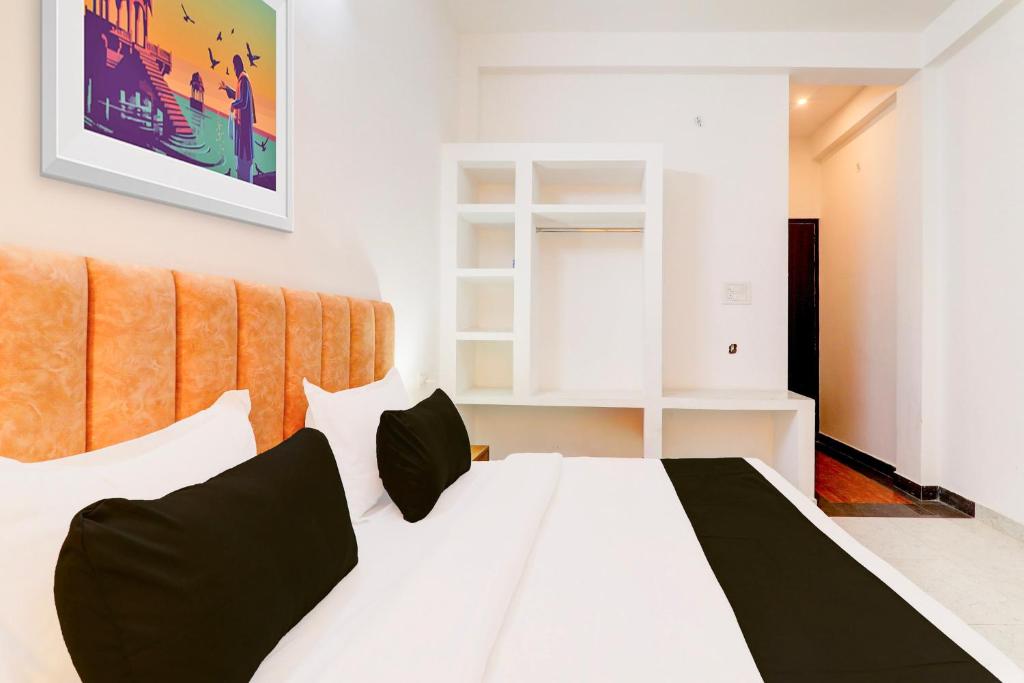 a bedroom with a white bed with black pillows at Hotel O Samar palace in Lucknow