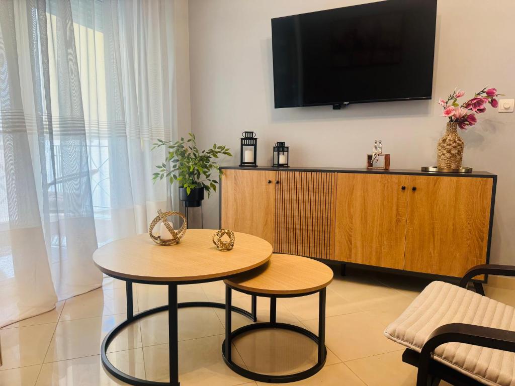 a living room with a table and a flat screen tv at Coastal Heaven in Neoi Epivates