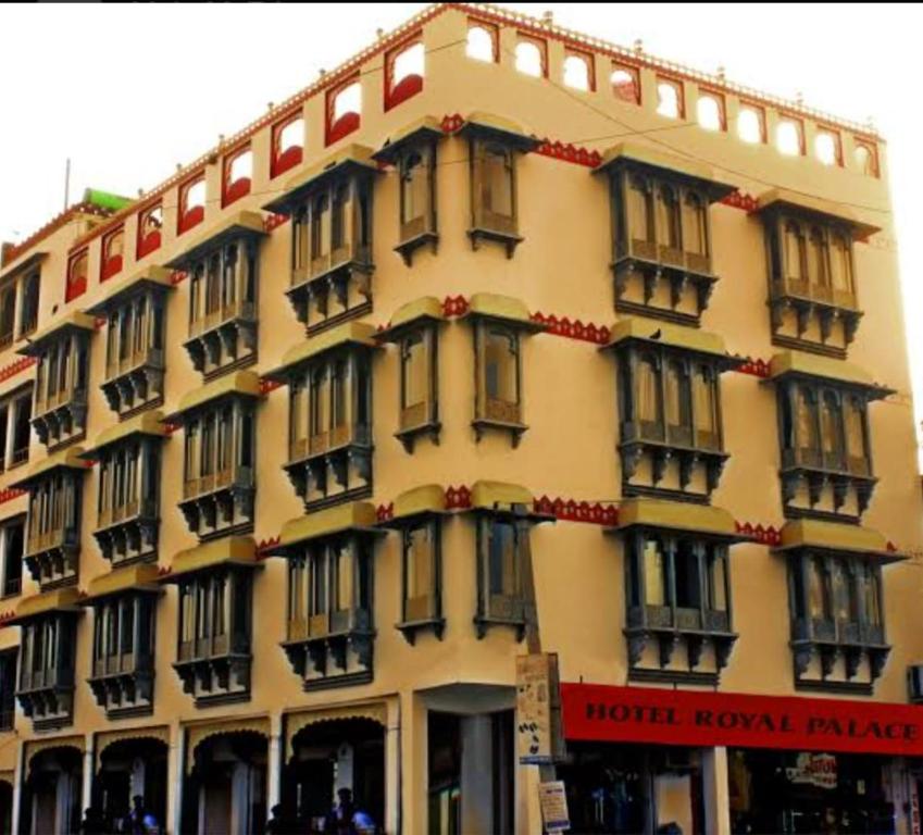a large yellow building with black windows on it at Hotel Royal Palace in Chittaurgarh