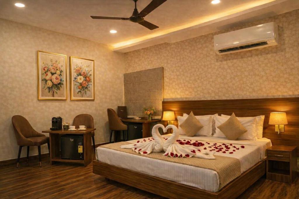 a bedroom with a bed with two swans on it at Grand Maalyasa Hotel and Suites, US Consulate Hyderabad 2 Mins walk in Hyderabad