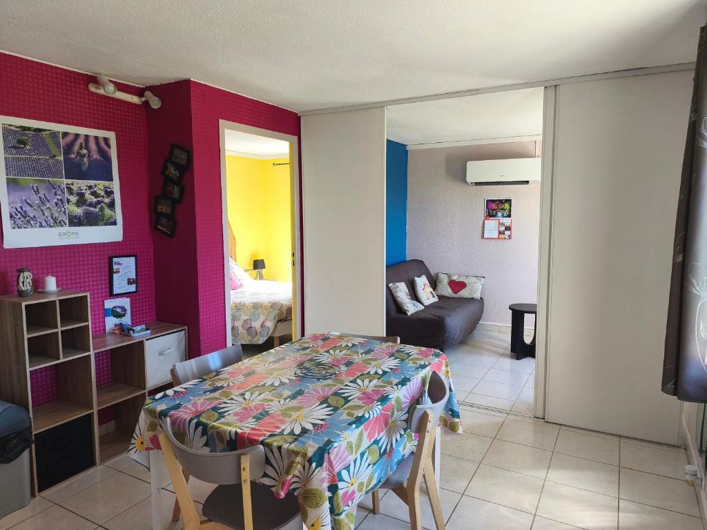 a room with a table and a room with a couch at Maison Tifaloc in Montélimar
