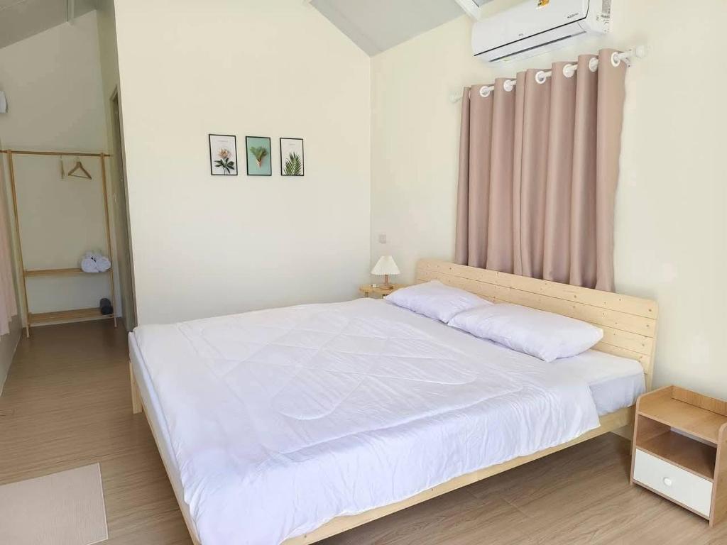 a bedroom with a large bed with white sheets at บ้านตัวเล็กศาลายา in Sathani Wat Suwan