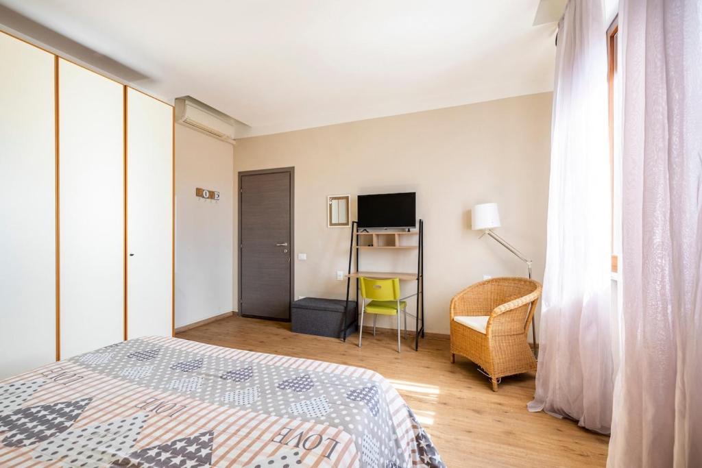 a bedroom with a bed and a desk and a television at Da Chiara in Pistoia
