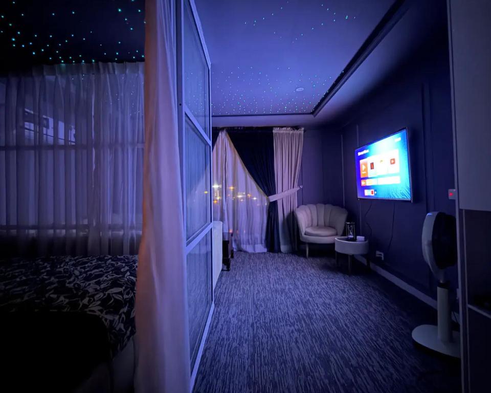 a hotel room with a bed and a television at premium category 2 bedrooms apartment in Lahore