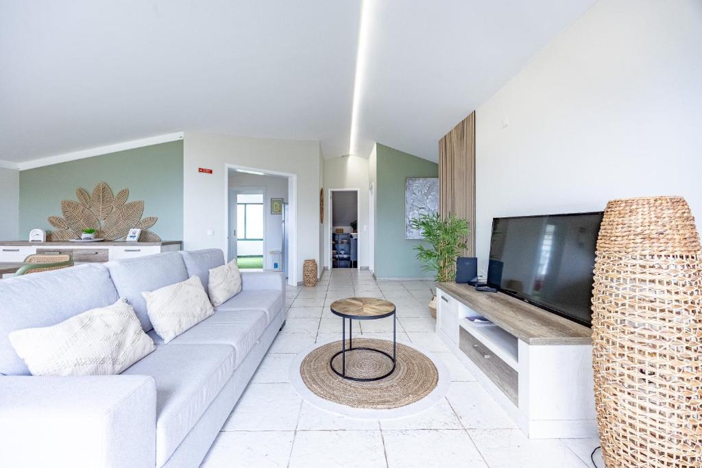 a living room with a couch and a flat screen tv at Paul Sun Scape - Seaside Ocean & Sunset View in Paul do Mar