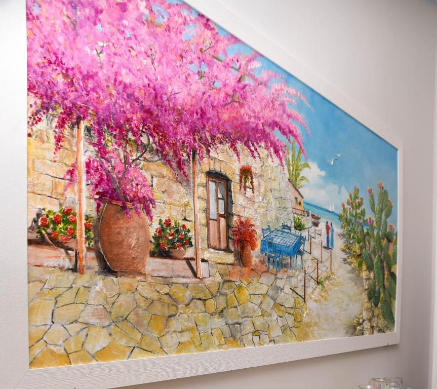 a painting of a house with pink flowers on a wall at DolceLina Home in Lampedusa