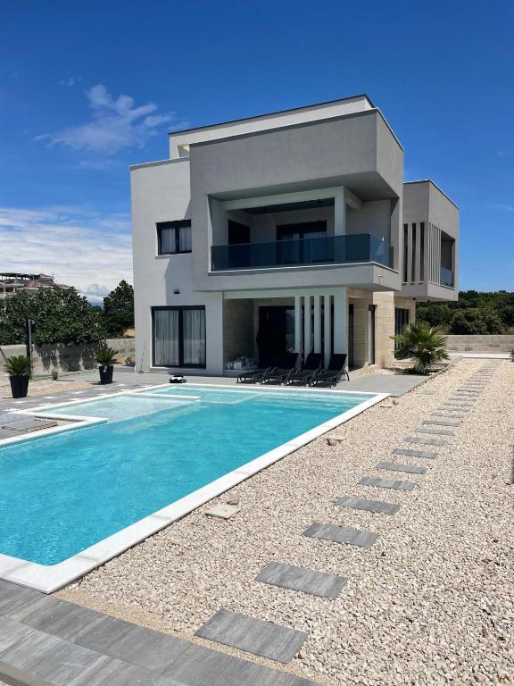 a house with a swimming pool in front of it at Villa Golden Star in Zaton