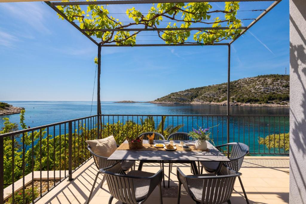 a table on a balcony with a view of the ocean at Villa Lavanda Deluxe in Rogoznica