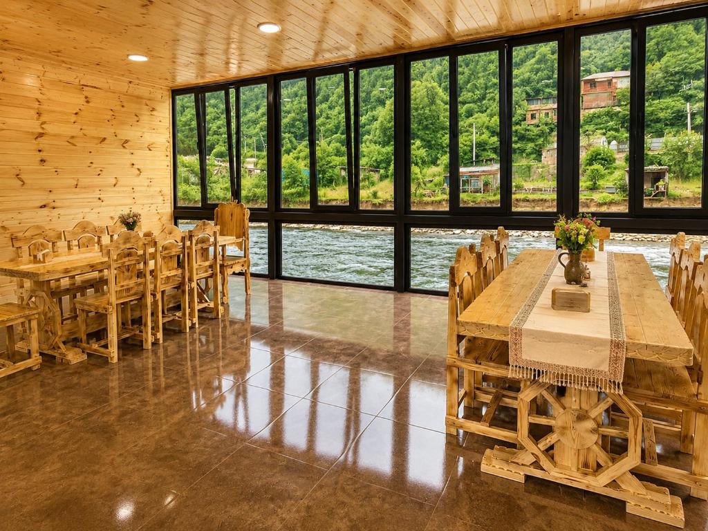 a dining room with tables and chairs and windows at River Light-Guest House in Alaverdi