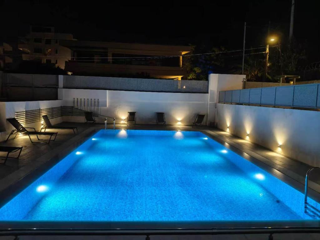 a swimming pool at night with lights on a building at Voula Pool & Sea View & Beach home B1 in Athens