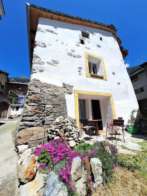 a building with a bunch of flowers in front of it at Casa Piazzo in Brusio