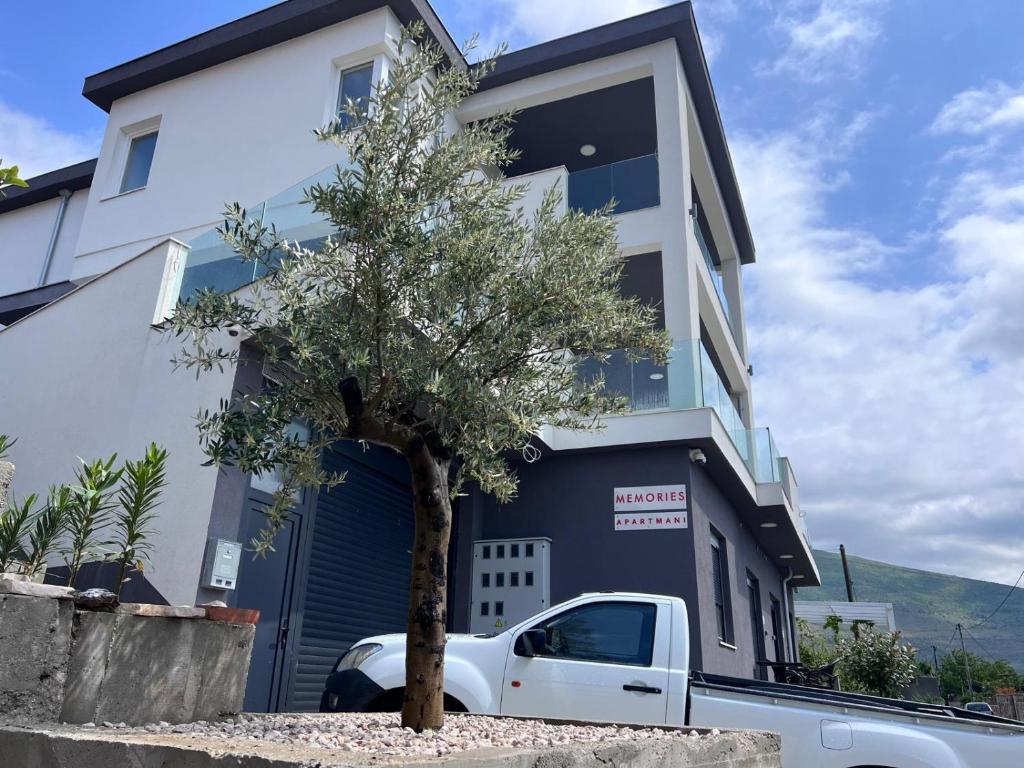 a white truck parked in front of a building at Apartments Memories EV ch 11kW available in Trebinje
