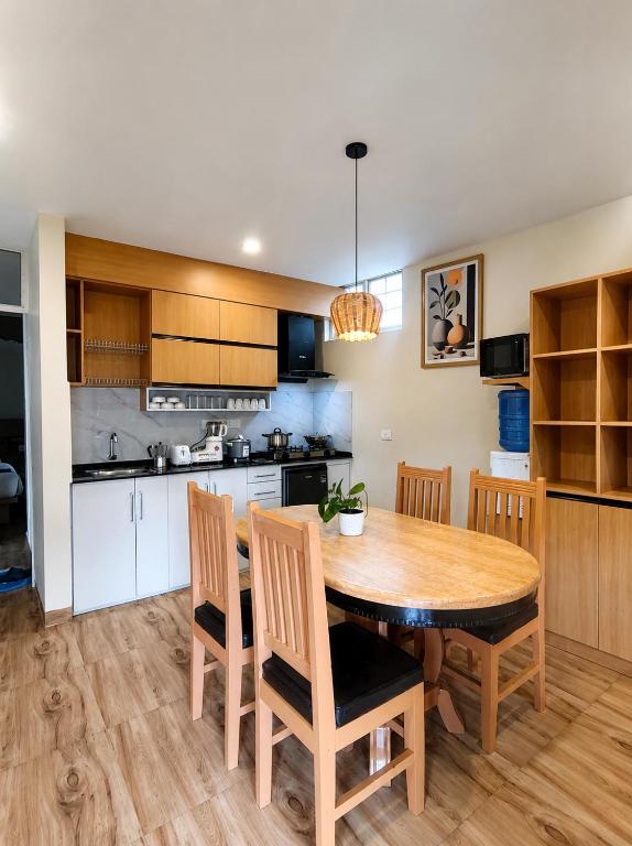 a kitchen and dining room with a wooden table and chairs at Pokhara Apartments Inn in Pokhara