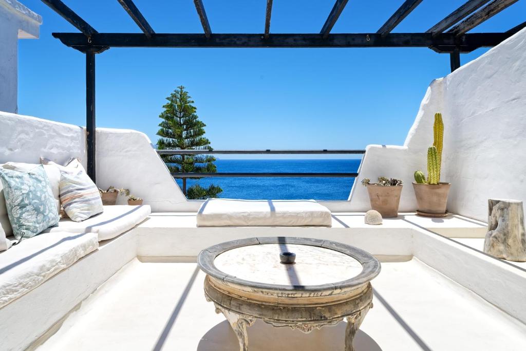 a living room with white furniture and a view of the ocean at Sardina Ocean Front Apartment in Gáldar