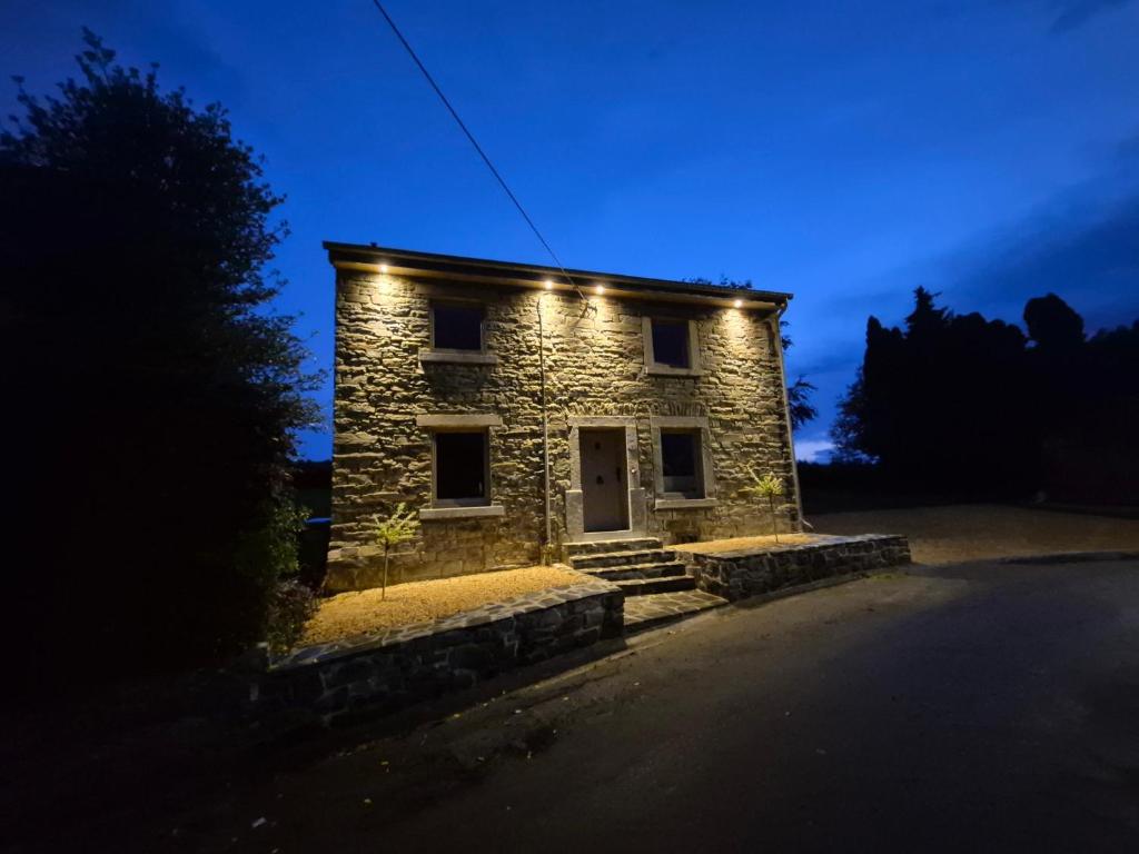 a stone house with lights on it at night at Le Petit Marcheloup in Paliseul