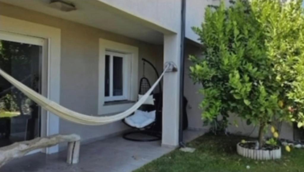 a hammock in front of a house with a tree at Location Vias in Vias