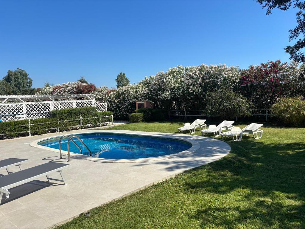 a swimming pool with lounge chairs and a patio at Villa Funtana Cortese in Orosei