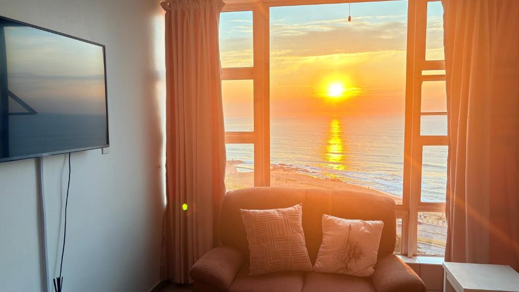 a room with a window with a view of the ocean at Oceans Whisper 704 beach apartment gated & Lift access in Scottburgh