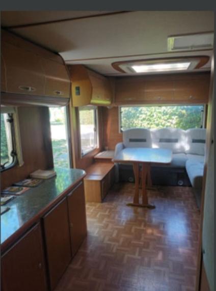 a train room with a kitchen and a table at Grande caravane in Gergy