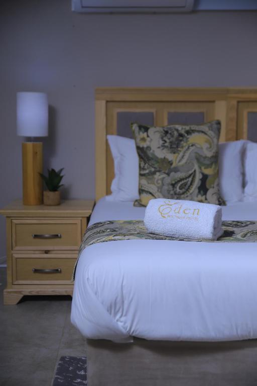 a bedroom with a bed with a sign on it at EDEN BOUTIQUE HOTEL in Kokstad