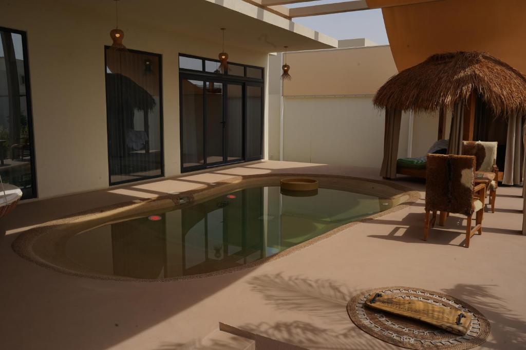 a house with a swimming pool in the middle of a room at Wabas Al Fanar in Rumays
