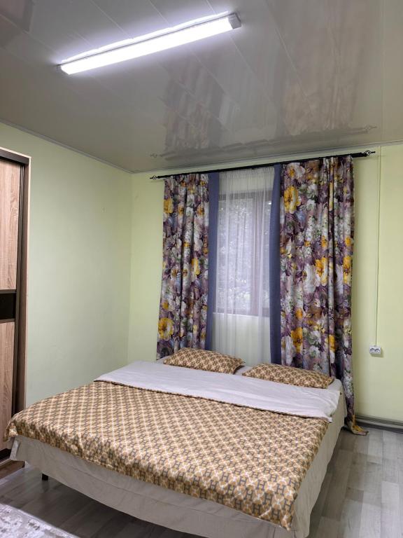 a bedroom with a bed in a room with curtains at Kolsay Amanat Resort in Kurmenty